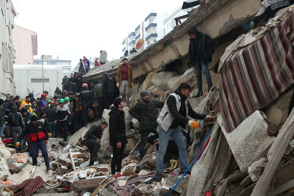 Rescue workers and volunteers conduct search-and-rescue operations in the rubble of a collapsed building in Diyarbakir, Turkey.
